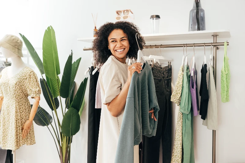 Blog 4 Laughing woman customer choosing sweatshirt in a store